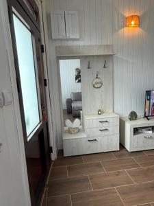 a bathroom with white cabinets and a mirror at Baja's Garden Apartman in Bajina Bašta