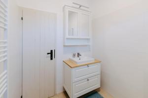 a white bathroom with a sink and a cabinet at Villa Vista Pannonia in Donnerskirchen +61 photos