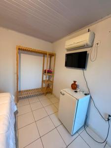 a small room with a refrigerator and a tv at Pousada Villa Cerrado in Caldas Novas