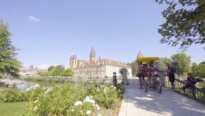 a person riding a bike on a path in front of a building at Les Gîtes du Chemin - La Colombière in Paray-le-Monial
