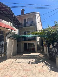a white house with a balcony and a driveway at Mila apartments in Prilep