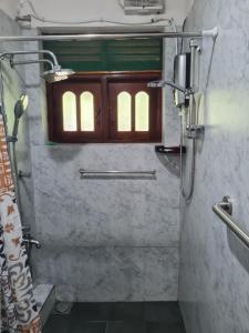 a bathroom with a shower with a window in it at Ama HomeStay Guest Colombo in Rajagiriya