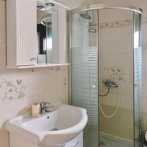 a bathroom with a sink and a glass shower at Blue Bay Apartments in Krašići +21 photos