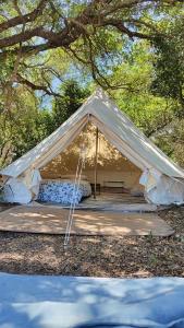 a white tent with a bed and a picnic table at Tulpa Cádiz in Malcocinado