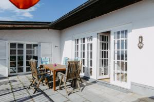 a patio with a wooden table and chairs at Villa Vista Pannonia in Donnerskirchen