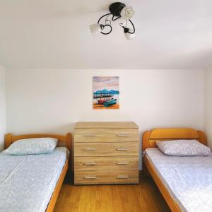 a bedroom with two twin beds and a dresser at Blue Bay Apartments in Krašići