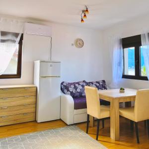 a kitchen with a table and a couch and a refrigerator at Blue Bay Apartments in Krašići