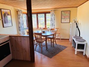 a kitchen and dining room with a table and chairs at Enkelt nära havet in Skummeslövsstrand