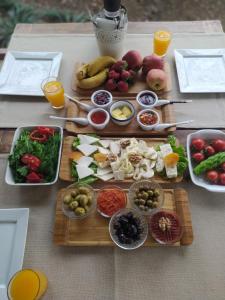 a table topped with plates of food and fruits and vegetables at Blue & White Hotel in Cıralı
