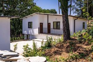 a white house with a tree in front of it at Бунгала " SEA VILLAGE DAR " in Kamchia