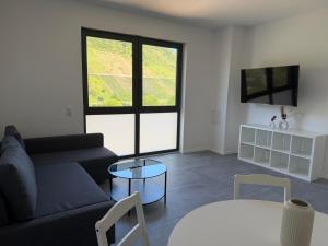 a living room with a couch and a table at Moselpanorama91 in Briedel