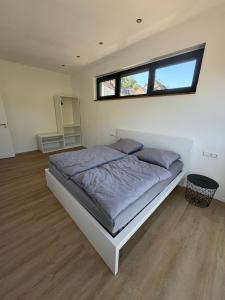 a bedroom with a bed with a window above it at Moselpanorama91 in Briedel