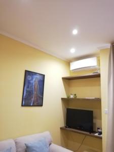 a living room with a couch and a tv at Candelieri Suites in Sassari
