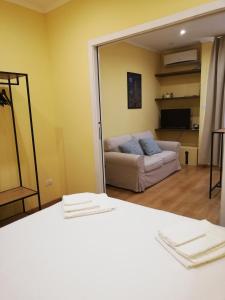 a room with a bed and a couch and a mirror at Candelieri Suites in Sassari