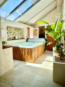 an indoor hot tub in a room with a window at Le Pré de la Mer Suite & SPA Privatif in Querqueville