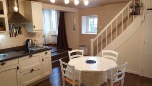 a kitchen with a table and chairs and a staircase at Gîte La Salamandre in Passenans