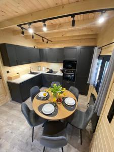 a kitchen and dining room with a table and chairs at Domek letniskowy Zacisze 2 in Urowo