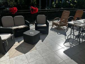 a patio with chairs and tables and a table and chairs at Willa Aqua -parking included in the price in Świnoujście
