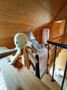 a stuffed octopus is sitting on a bed in a room at Domki Sielankowo in Odargowo
