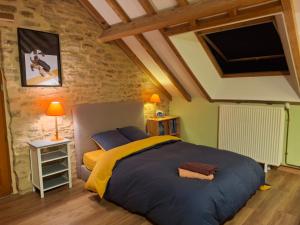a bedroom with a large bed in a stone wall at Au Lou Pélélée in Madranges