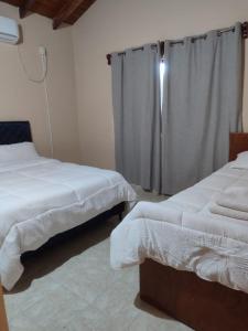 a bedroom with two beds and a shower curtain at Casa con dos Dormitorios in Encarnación
