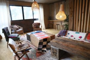 a living room with a couch and chairs and a table at ゲストハウスよるよなか in Nagoya