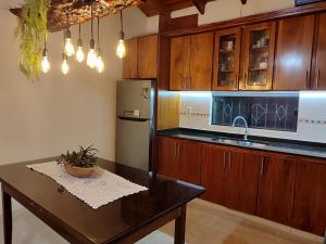 a kitchen with a table and a refrigerator at Casa con dos Dormitorios in Encarnación