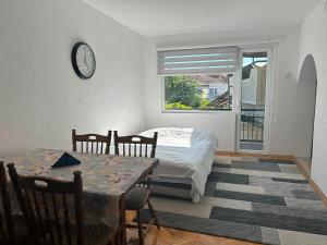 a bedroom with a bed and a table and a clock at Mila apartments in Prilep
