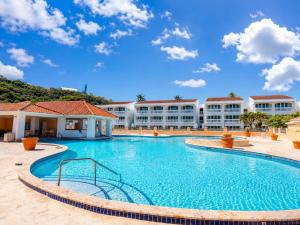a swimming pool at a resort with buildings in the background at Golden Dream Studio 2nd floor B in Isabela