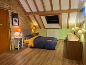 a bedroom with a bed and a desk and a tv at Au Lou Pélélée in Madranges +12 photos