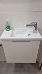 a white bathroom sink with a soap bottle on it at Appartment Auszeit in Schönwald +20 photos
