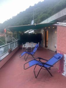 a patio with blue chairs and tables on a balcony at La casa di RÒ in Avegno
