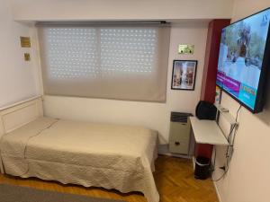 a bedroom with a bed and a flat screen tv at Corrientes Center in Buenos Aires