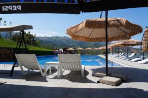 a group of chairs and umbrellas next to a swimming pool at Fayz Mount Residence in Chimgan
