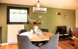 a dining room with a wooden table and chairs at Meikever in Putten