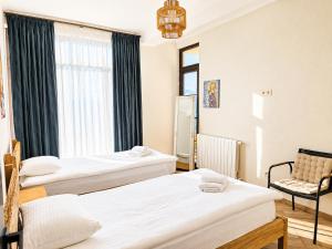 a room with three beds and a chair and a window at Datvina Panorama Chalets Mravaldzali, Racha in Oni
