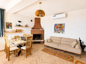 a living room with a table and a couch and a fireplace at Datvina Panorama Chalets Mravaldzali, Racha in Oni