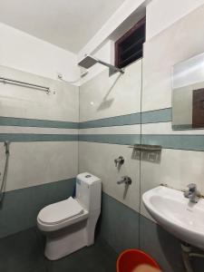 a bathroom with a toilet and a sink at K K Residency in Alwaye