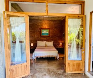 a room with a bed and a glass door at Villa Poesía in Puerto Escondido