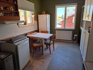 a kitchen with a table and a white refrigerator at Tulip Adventure in Deje