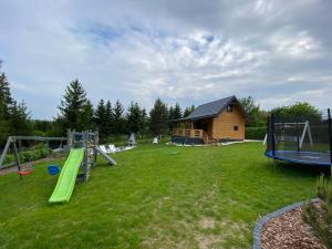 a group of playground equipment in front of a house at Domek letniskowy Zacisze 2 in Urowo