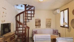 a living room with a spiral staircase in a room at Kyveli Homes in Therma