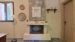a room with a fireplace with a sink and a mirror at Kyveli Homes in Therma