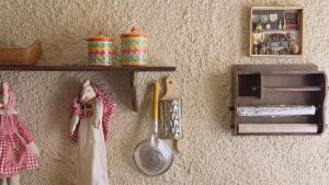 a wall with shelves and dolls and a utensils at Kyveli Homes in Therma
