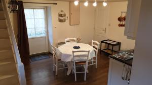 a kitchen with a table and chairs in a kitchen at Gîte La Salamandre in Passenans +11 photos
