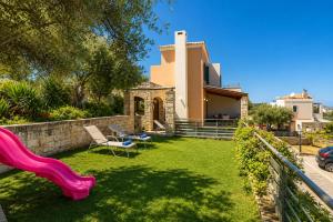 a house with a yard with a slide at Margarita's Villas in Chania