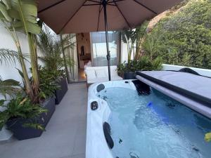 a hot tub on a patio with an umbrella at Aiolos Suites in Rhodes Town