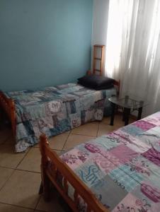 a bedroom with two beds and a table in it at Hibberdene See to Sea in Hibberdene