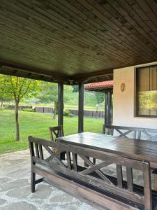 a wooden table and benches on a patio at Villa Foresta in Oreshak
