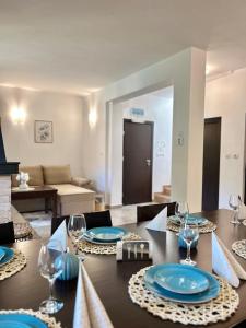 a dining room with a table with blue plates and glasses at Villa Foresta in Oreshak